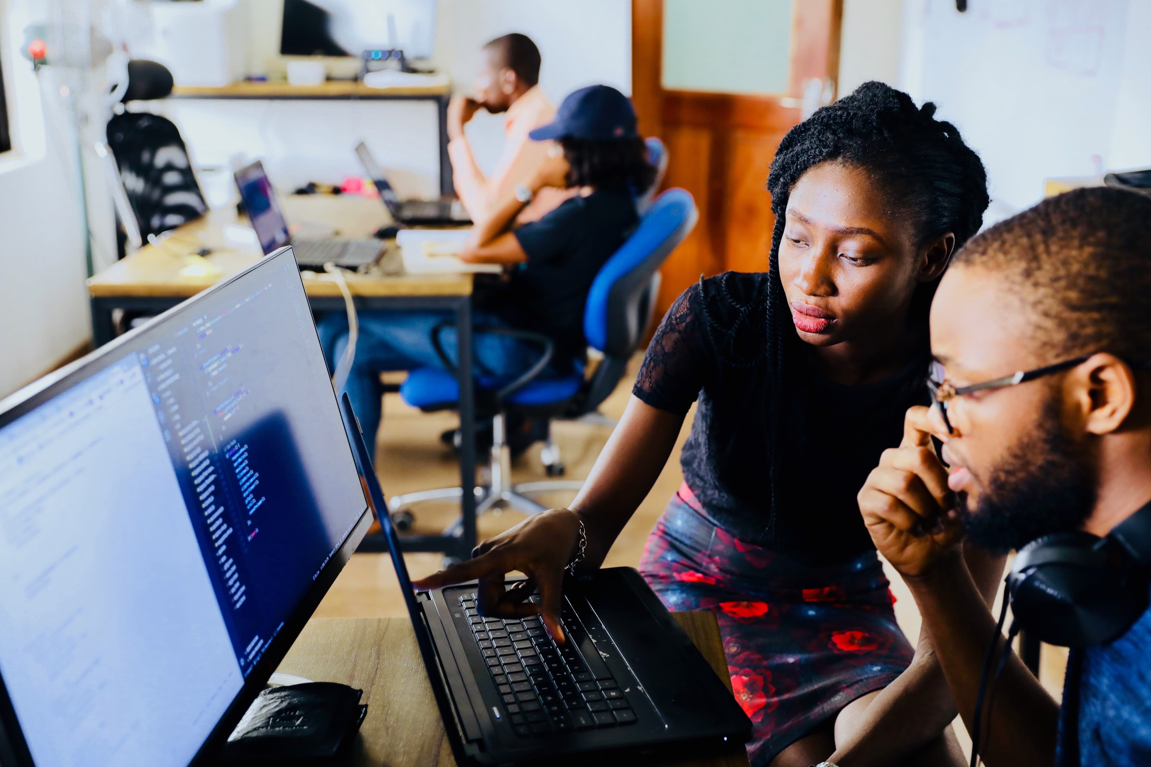 2 people leaning over a computer